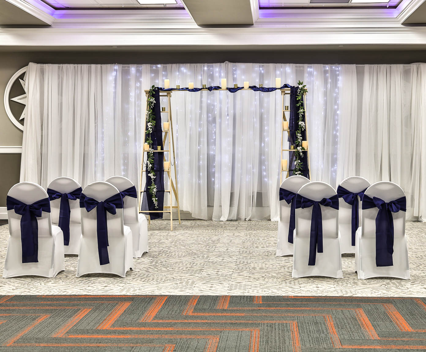 Ceremony arch with chairs and draping lights